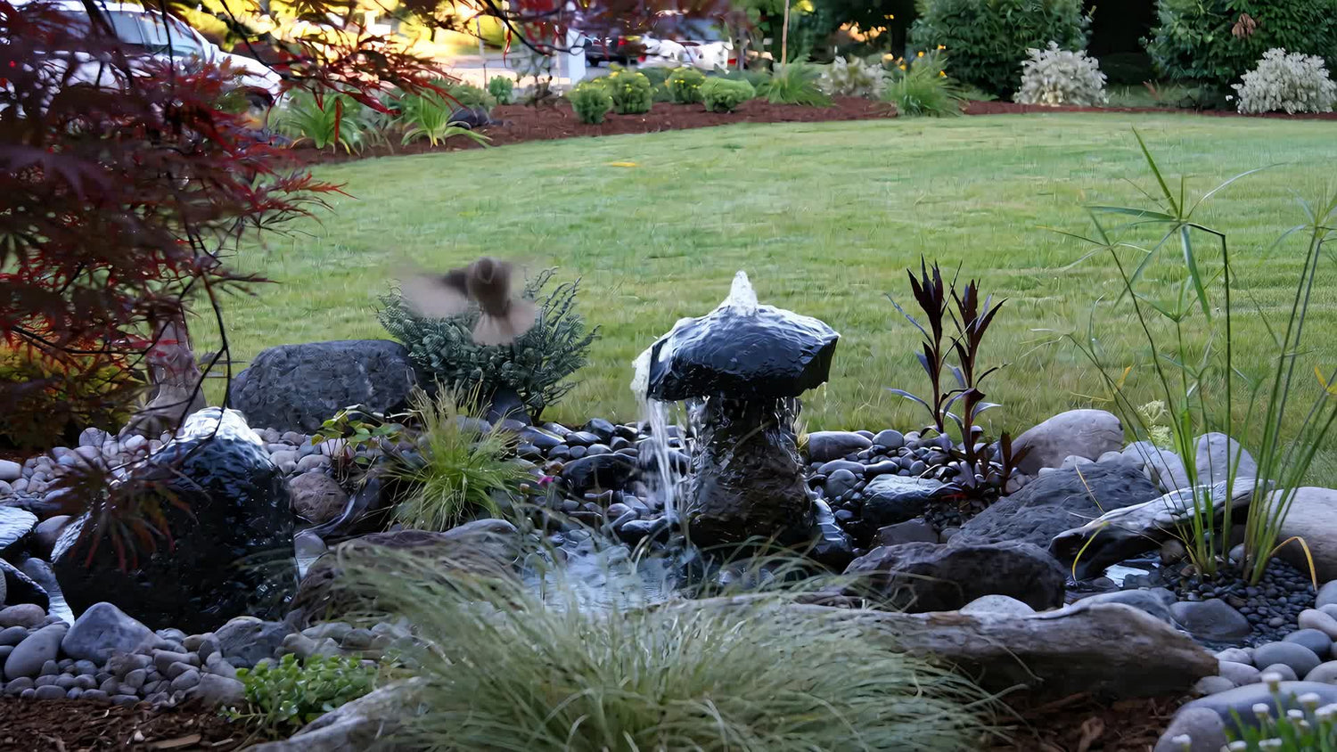 Hummingbird drinking from a handcrafted stone fountain